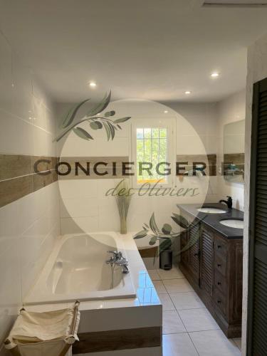 une salle de bain avec une baignoire et un lavabo dans l'établissement Villa avec piscine, à Belgentier