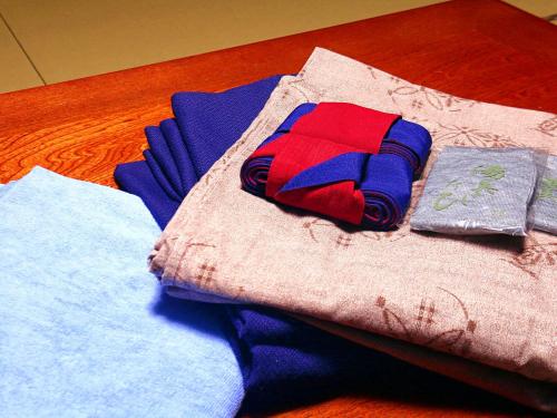 a pile of clothing on a wooden table at Minshuku Kanjiya in Shirakawa