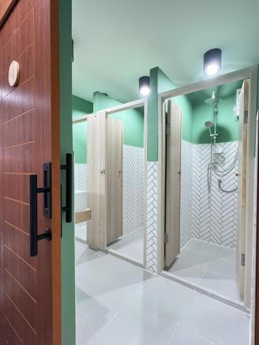 a bathroom with a mirror and a shower at Ease at Sathorn Hostel and Coworking Space in Bangkok