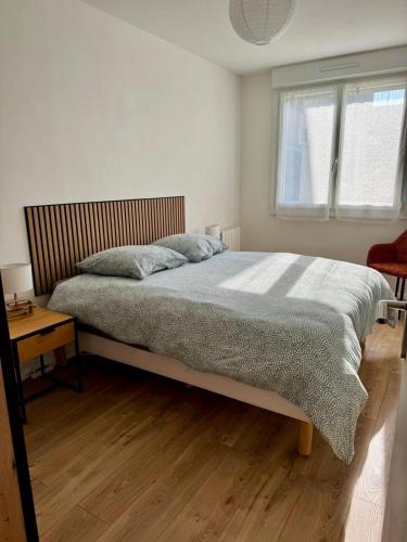 une chambre avec un grand lit et une fenêtre dans l'établissement Serenity, appt avec loggia à 5min de la plage, à Courseulles-sur-Mer