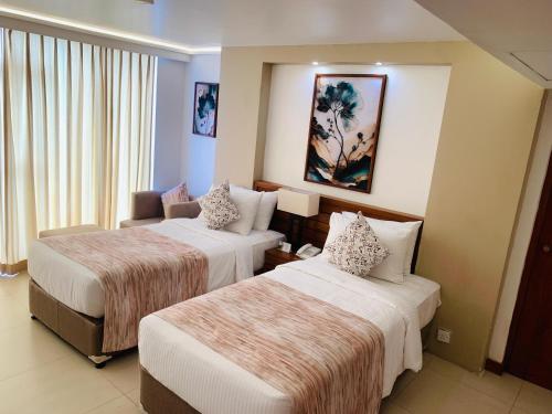 a hotel room with two beds and a couch at Pegasus Reef - A Beach Resort in Colombo in Colombo