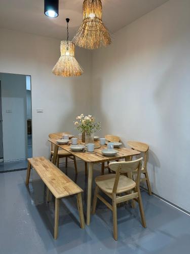 a dining room with a wooden table and chairs at Ease at Sathorn Hostel and Coworking Space in Bangkok