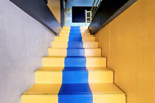 a stairway with blue and yellow stairs in a building at Me U Hostel in Chiang Mai