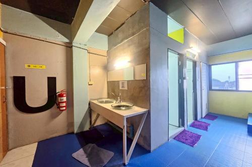 a bathroom with a sink in a room at Me U Hostel in Chiang Mai