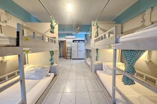 a room with three bunk beds and a hallway at Me U Hostel in Chiang Mai