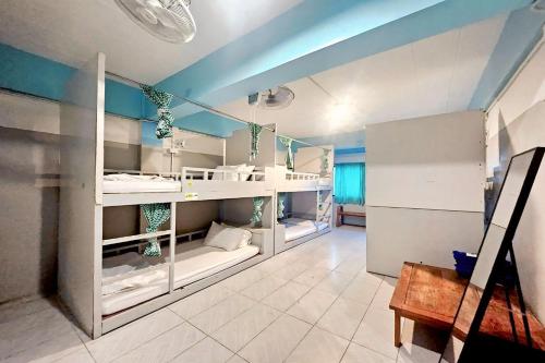a room with white bunk beds and blue walls at Me U Hostel in Chiang Mai