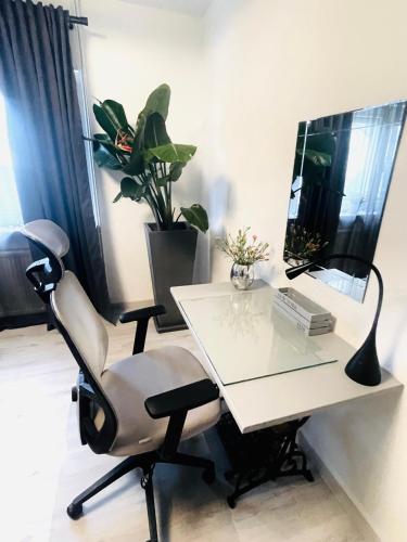 a white desk with a chair and a mirror at Cosmopolitan in Paderborn