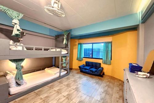 a room with two bunk beds and a couch at Me U Hostel in Chiang Mai