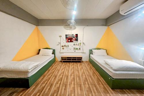 two beds in a room with orange and white walls at Me U Hostel in Chiang Mai