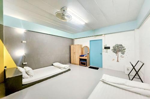 a room with two beds and a blue door at Me U Hostel in Chiang Mai