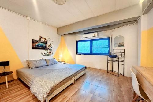 a bedroom with a bed and a large window at Me U Hostel in Chiang Mai
