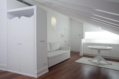 a white living room with a white couch and a table at Mercearia da Vila in Ponte de Lima