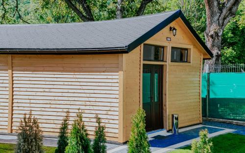 a large wooden garage with a black roof at Roben Village in Suseni