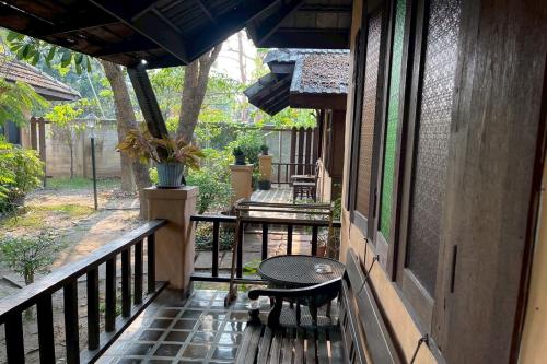 a porch with a table and a bench on a balcony at The Royal Shilton Resort in Chiang Mai