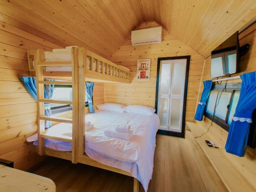 a bedroom with bunk beds in a wooden cabin at Roben Village in Suseni