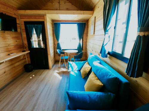a living room with a blue couch and a table at Roben Village in Suseni