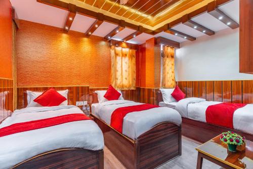 a room with three beds with red pillows at OYO 830 Hotel Amrit Kunja in Kathmandu
