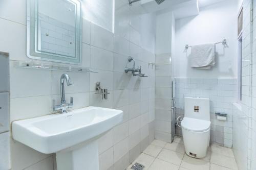 a white bathroom with a sink and a toilet at OYO 830 Hotel Amrit Kunja in Kathmandu
