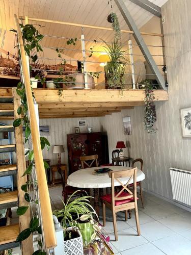 Cette chambre comprend une table, des chaises et des plantes. dans l'établissement Maison - Charentaise de charme, à Saint-Palais-sur-Mer