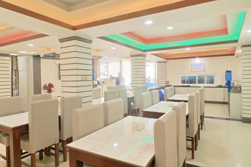 a dining room with tables and white chairs at OYO 828 Hotel White Dreams Palace in Kathmandu
