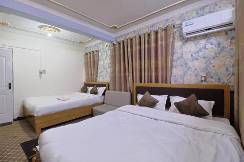 a hotel room with two beds and a tv at OYO 828 Hotel White Dreams Palace in Kathmandu