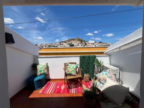 a balcony with a table and chairs on a roof at Casa Das Estrelas Vista Mertola Praia Fluvial in Mértola