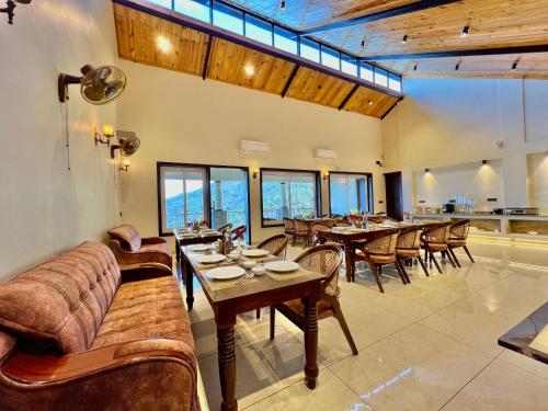 Un comedor con mesas y sillas y ventanas. en The Dunhill Manor, en Lansdowne