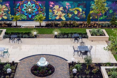 a patio with tables and chairs in front of a mural at Clybaun Hotel in Galway