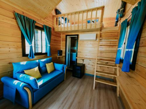 a blue couch in a room with wooden walls at Roben Village in Suseni