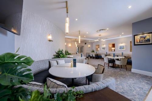 a lobby with a couch and tables and chairs at Clybaun Hotel in Galway