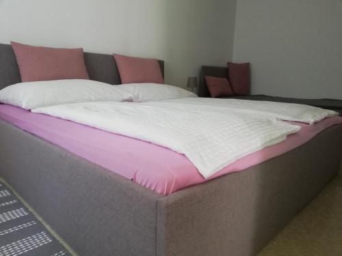 a bed with a pink and white blanket on it at Appartmenthaus Josefikeller in Podersdorf am See