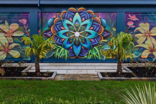 two palm trees in front of a wall with a mural at Clybaun Hotel in Galway