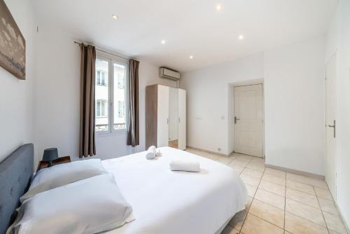 une chambre avec un grand lit blanc et une fenêtre dans l'établissement 2 Pièces vieille-ville Cannes - Suquet - Proche Palais et Croisette, à Cannes