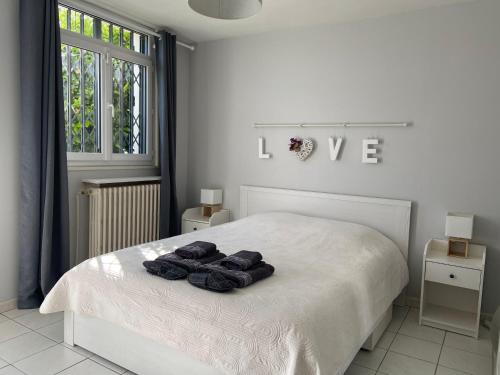 a white bedroom with a bed with towels on it at Sweet Home - 55m2 appartment, garden, swimming pool, parking in Toulouse