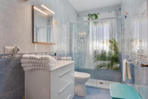 a bathroom with a toilet and a shower and a sink at Chalet Novo Sancti Petri Surf in Chiclana de la Frontera