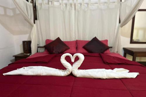 two swans made to look like hearts on a bed at The Royal Shilton Resort in Chiang Mai