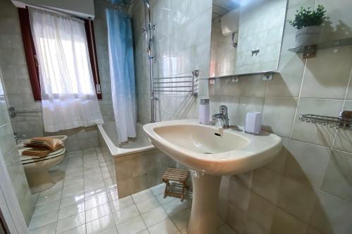 a white bathroom with a sink and a toilet at Casa Magnanina Sarda in Oristano