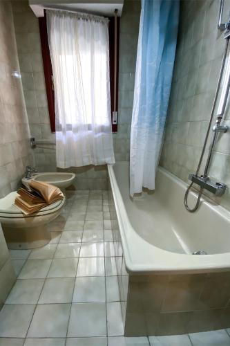 a bathroom with a toilet and a tub and a sink at Casa Magnanina Sarda in Oristano
