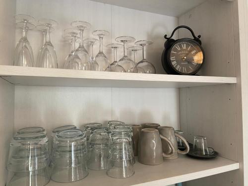 a shelf with glass jars and a clock on it at Sweet Home - 55m2 appartment, garden, swimming pool, parking in Toulouse