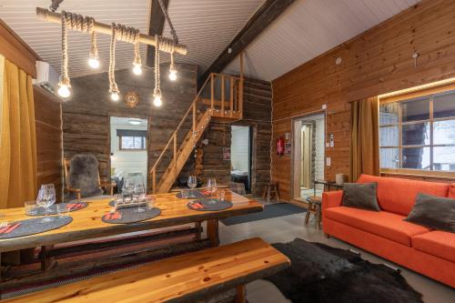 a living room with a table and a couch at Kuukkeli Log Houses Aurora Cabin - Jaspis in Saariselka