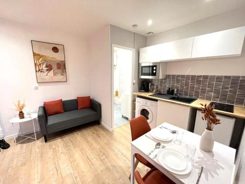 une cuisine et un salon avec une table et un canapé dans l'établissement Le Terracotta proche Centre Ville et Caserne, à Chalon-sur-Saône