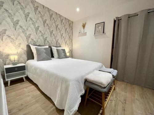 a bedroom with a large bed with a white comforter at Le Terracotta proche Centre Ville et Caserne in Chalon-sur-Saône