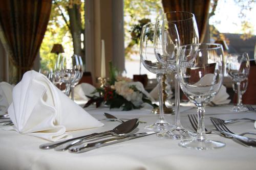 a table with glasses and silverware on a white table cloth at Hotel Alte Mark in Hamm