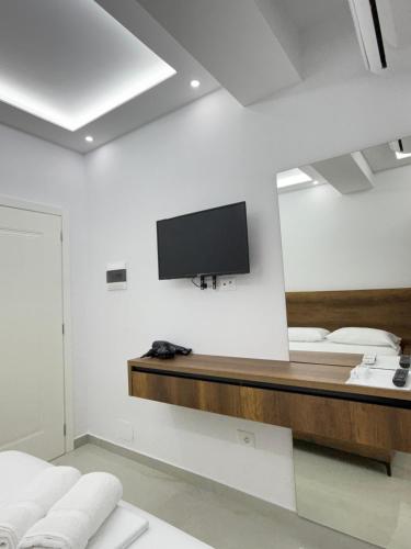 a room with two beds and a tv on the wall at Villa Papa-Berat in Berat