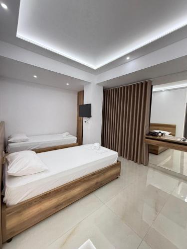 a hotel room with two beds and a window at Villa Papa-Berat in Berat