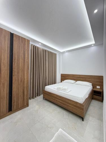 a bedroom with a large bed with white sheets at Villa Papa-Berat in Berat