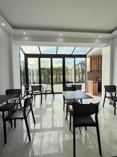 a dining room with tables and chairs and windows at Villa Papa-Berat in Berat