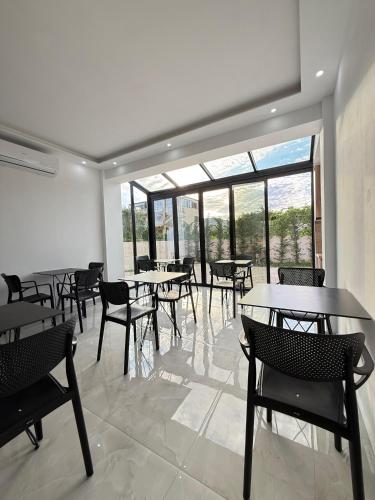 a dining room with tables and chairs and windows at Villa Papa-Berat in Berat
