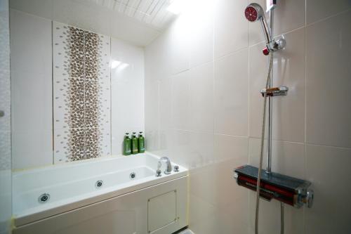 a white bathroom with a shower and a sink at Gamyoungroo Hanok Hotel in Jeonju
