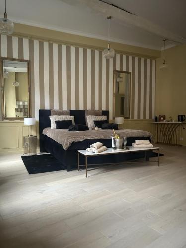 a large bedroom with a bed and a coffee table at La suite Isabelle de Luxembourg & Spa in Béthune